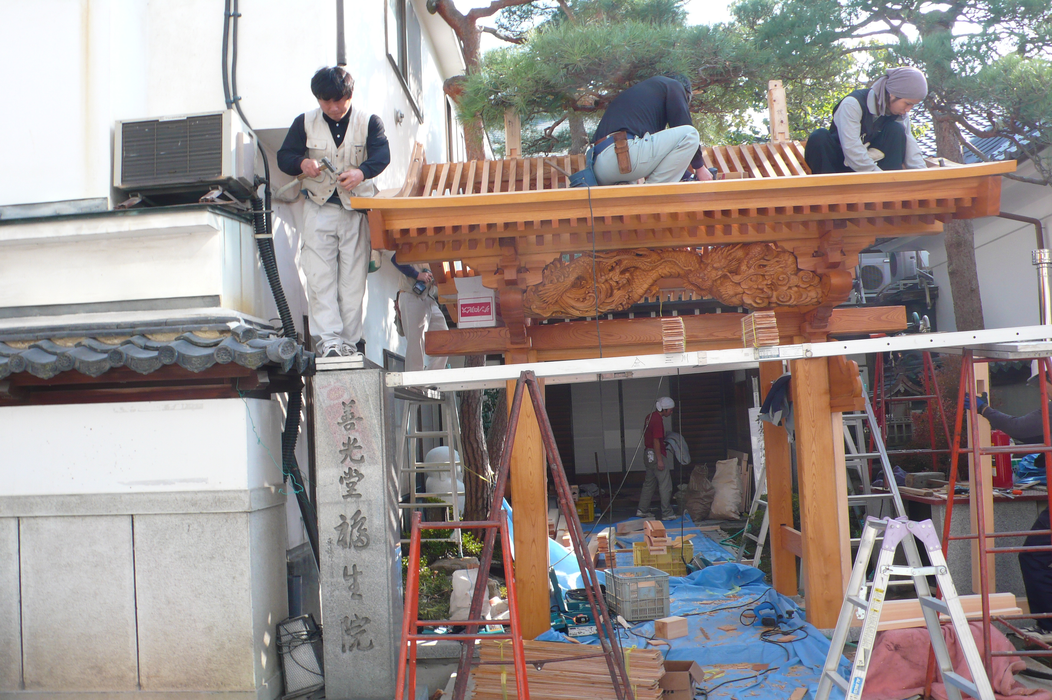 昨日は龍の彫り物を門に取付けていましたが  今朝,様子を見に伺いましたら、もう屋根が出来ていました。